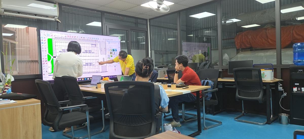 Kỹ sư trình bày layout kho chứa nguyên liệu trên màn hình lớn